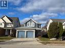 View of front of property featuring concrete driveway, a shingled roof, and a porch - 110 Adler Drive, Cambridge, ON  - Outdoor With Facade 