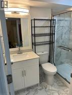 Full bath featuring light marble finish floors, vanity, and a marble finish shower - 