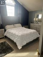 Bedroom with carpet floors, vaulted ceiling, and a textured ceiling - 