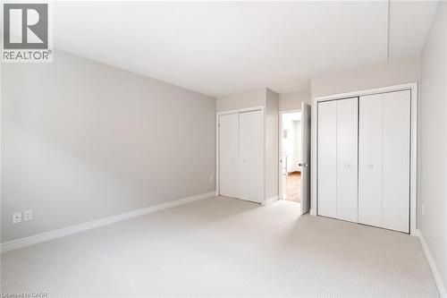 Unfurnished bedroom featuring multiple closets, baseboards, and light carpet - 2340 King Street E, Hamilton, ON - Indoor Photo Showing Other Room