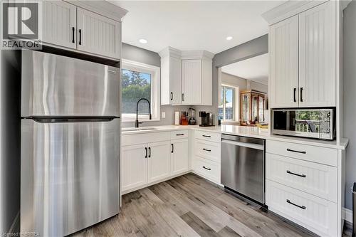 Kitchen with appliances with stainless steel finishes, light wood-type flooring, healthy amount of natural light, white cabinetry, and recessed lighting - 1565 Old Brock Street, Vittoria, ON - Indoor Photo Showing Kitchen