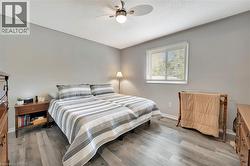 Bedroom with ceiling fan, wood finished floors, and a textured ceiling - 