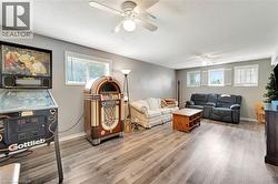 Living room with plenty of natural light, light wood-style floors, a textured ceiling, and ceiling fan - 