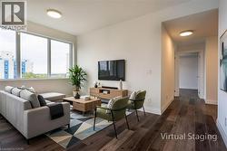 Living room featuring dark wood-style floors and baseboards - 