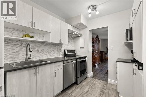 Kitchen with open shelves, stainless steel appliances, dark countertops, and tasteful backsplash - 350 Quigley Road Unit# 512, Hamilton, ON - Indoor Photo Showing Kitchen With Upgraded Kitchen