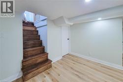 Staircase with wood finished floors and baseboards - 
