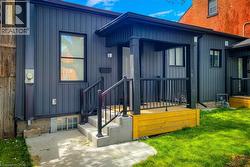 Property entrance with board and batten siding and a lawn - 