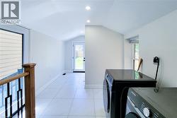 Laundry room with vaulted ceiling, recessed lighting, and washer and clothes dryer - 