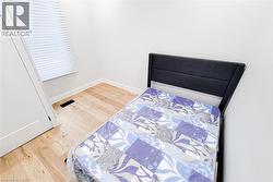 Bedroom with light wood-style floors and baseboards - 