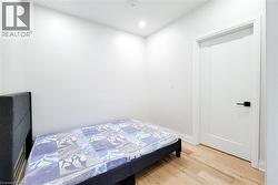 Bedroom with light wood finished floors and recessed lighting - 