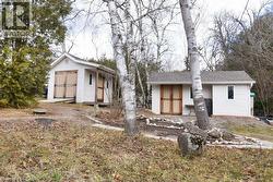 View of front of property with a shingled roof and a storage unit - 