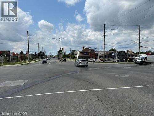 View of asphalt road with street lights, sidewalks, and curbs - 1360 E Rymal Road E, Hamilton, ON 