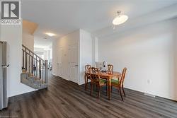 Dining area with stairs and dark wood-style flooring - 