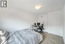 Carpeted bedroom with an office area and baseboards - 