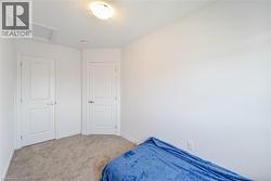 Bedroom with attic access and light carpet - 