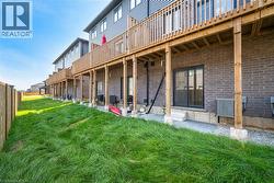 Back of property with brick siding, a patio, and a deck - 