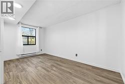 Unfurnished room featuring light wood finished floors and baseboard heating - 