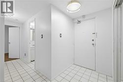 Entryway with a textured ceiling and light tile patterned floors - 