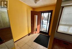 Foyer with a textured ceiling and light tile patterned floors - 