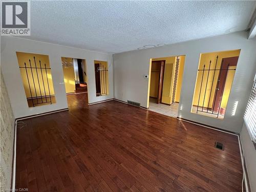 wood-style flooring and a textured ceiling - 185 Lavina Crescent, Hamilton, ON - Indoor Photo Showing Other Room