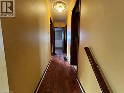 Hallway with dark wood-style flooring and a textured ceiling - 