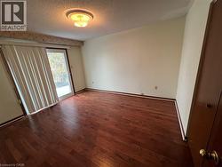 Primary bedroom with hardwood floors and sliding door to Balcony - 