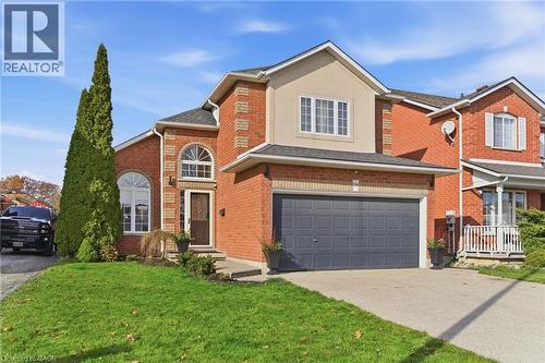 Traditional-style home with brick siding, concrete driveway, a front lawn, and a garage - 136 Braemar Avenue, Caledonia, ON - Outdoor With Facade