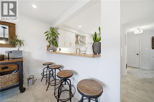 Kitchen with white cabinetry, a breakfast bar area, butcher block countertops, wall chimney exhaust hood, and recessed lighting - 136 Braemar Avenue, Caledonia, ON - Indoor Photo Showing Other Room