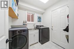 Laundry room with washer and dryer and a sink - 