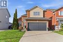 Traditional-style house featuring brick siding, concrete driveway, a front lawn, an attached garage, and stucco siding - 136 Braemar Avenue, Caledonia, ON  - Outdoor With Facade 