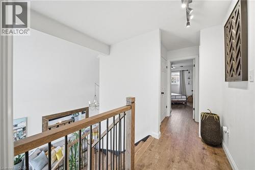 Hallway with light wood-type flooring, an upstairs landing, and a chandelier - 136 Braemar Avenue, Caledonia, ON - Indoor Photo Showing Other Room