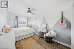 Bedroom with wood finished floors and a ceiling fan - 