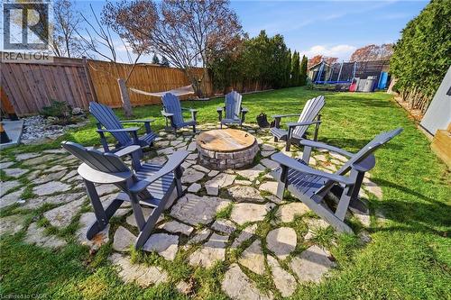 Fenced backyard with a trampoline, an outdoor fire pit, and a patio - 136 Braemar Avenue, Caledonia, ON - Outdoor With Backyard