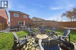 Fenced backyard featuring a patio, an outdoor fire pit, and a hot tub - 