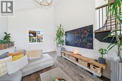 Living room with high vaulted ceiling, a chandelier, and wood finished floors - 