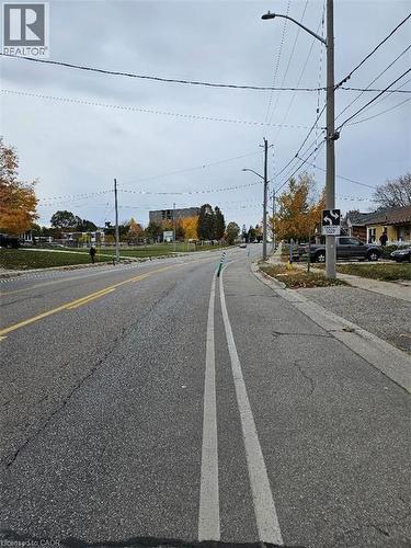 View of asphalt street with street lighting, curbs, and sidewalks - 1154 Queens Boulevard, Kitchener, ON - Outdoor With View