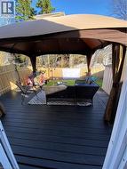 Wooden terrace with a gazebo, a fenced backyard, and outdoor lounge area - 