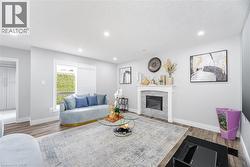 Living room featuring recessed lighting, a glass covered fireplace, wood finished floors, and a textured ceiling - 