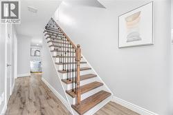 Staircase featuring a textured ceiling, wood finished floors, and baseboards - 
