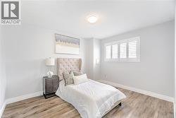 Bedroom featuring a textured ceiling, wood finished floors, and baseboards - 