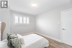Bedroom featuring baseboards, wood finished floors, and a textured ceiling - 