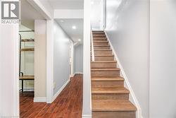 Stairway with baseboards, recessed lighting, and wood finished floors - 