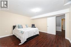 Bedroom with visible vents, baseboards, and wood finished floors - 