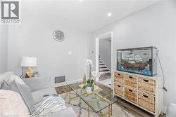 Living area featuring stairway, visible vents, baseboards, and wood finished floors - 