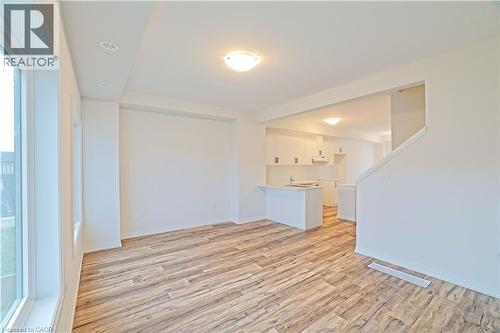 Unfurnished living room featuring light wood-style flooring and baseboards - 155 Equestrian Way Unit# 114, Cambridge, ON - Indoor