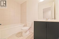 Bathroom with light tile patterned floors, vanity, and shower / tub combination - 