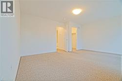 Unfurnished room featuring light colored carpet and baseboards - 