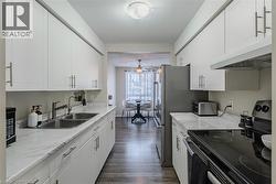 Kitchen with electric range, under cabinet range hood and white cabinetry - 