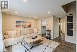 Living room featuring dark wood-style flooring and recessed lighting - 