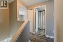 Corridor featuring an upstairs landing, dark wood-type flooring, and a textured ceiling - 